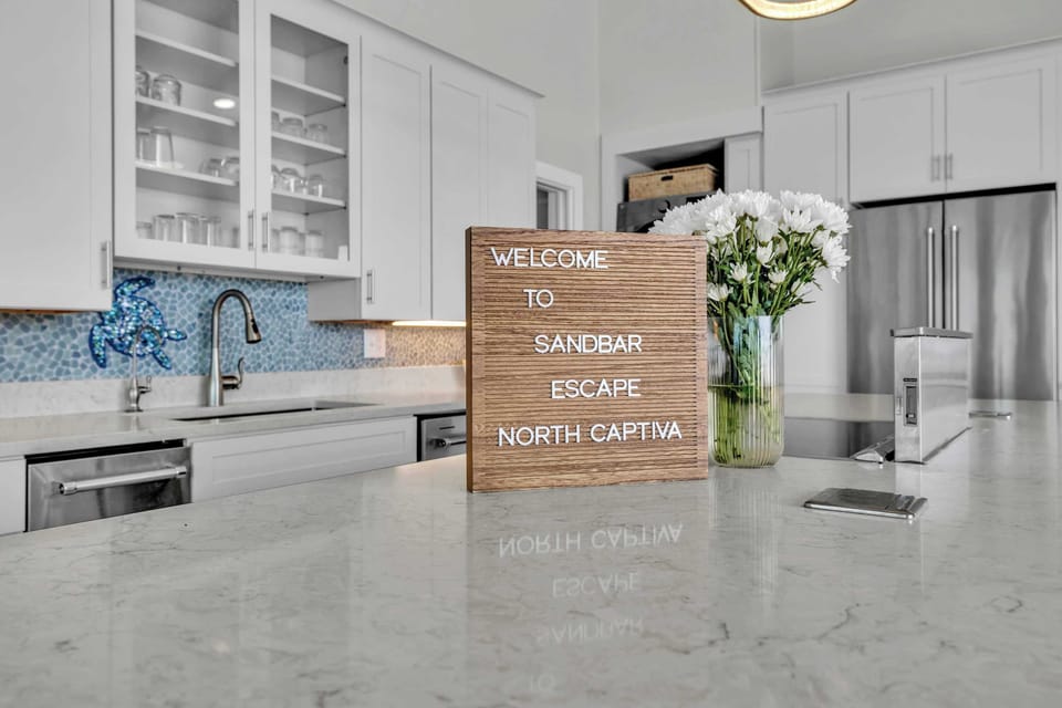 Start your stay at Sandbar Escape in this light-filled kitchen, designed for gathering, cooking, and effortless island living