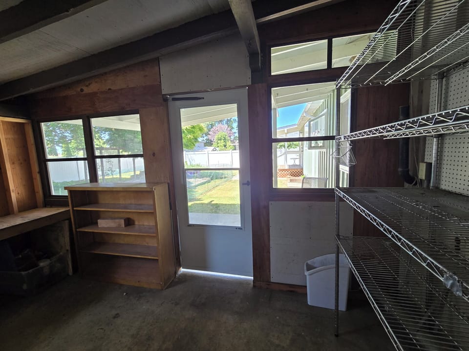 Bright utility room with shelving and easy backyard access