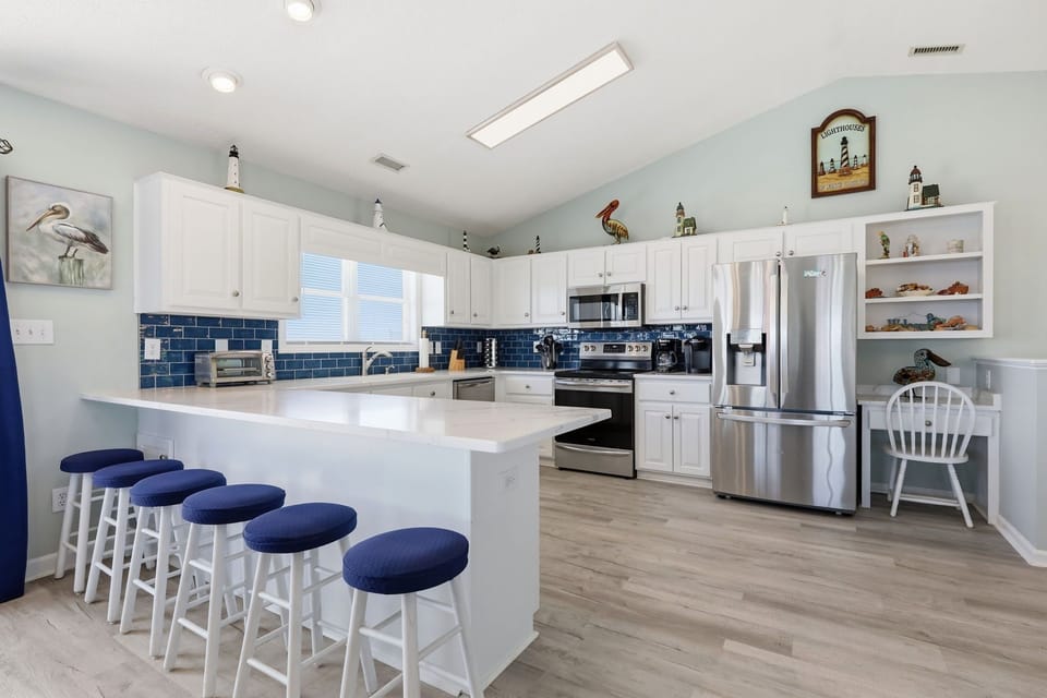 Gather around the spacious island with seating for five in this bright, coastal-inspired kitchen where you'll love preparing meals with modern appliances and ample counter space.