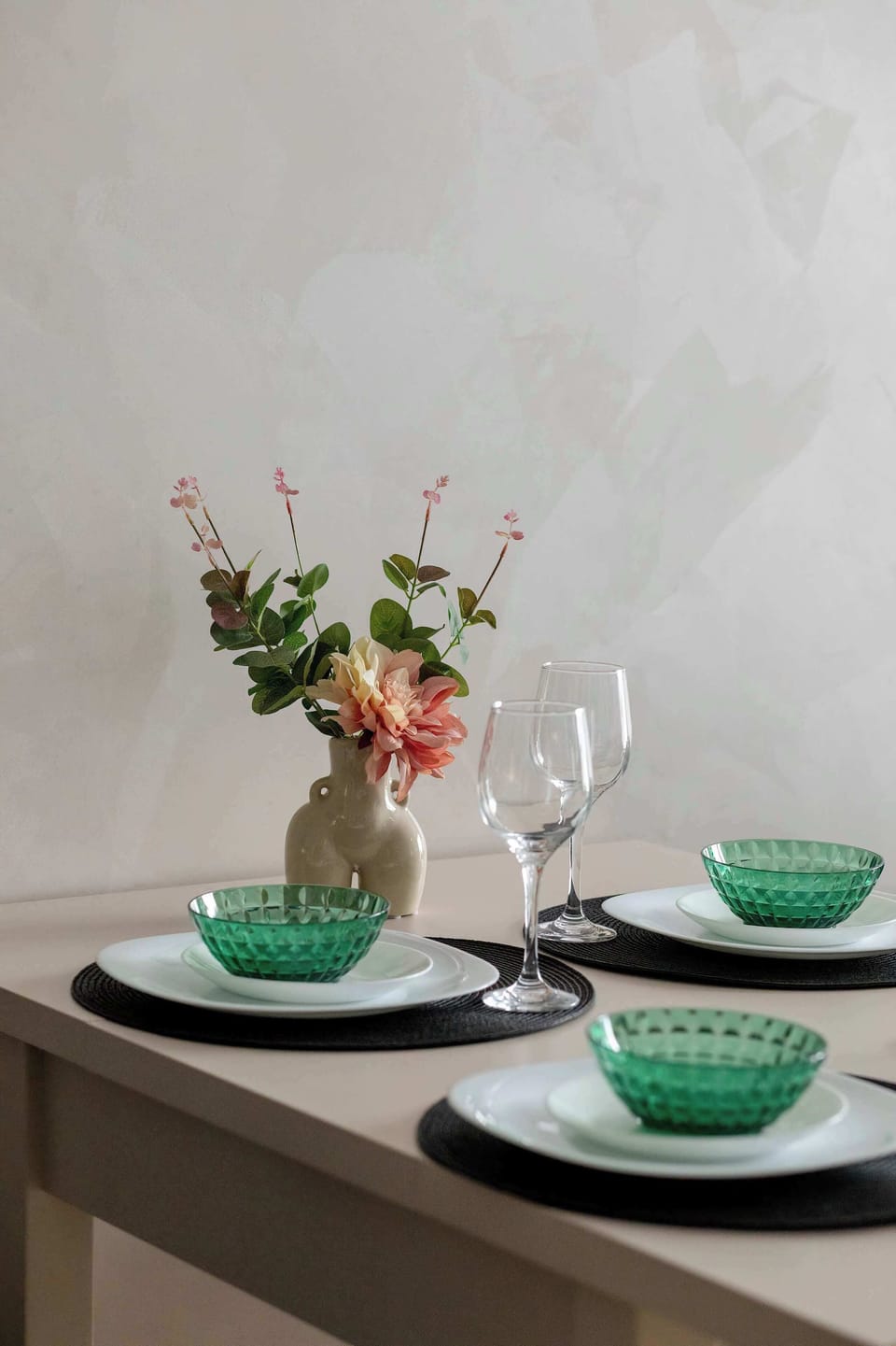 A kitchen countertop with neatly arranged tableware and decor. Clean surfaces emphasize the modern design. The area feels organized and elegant.