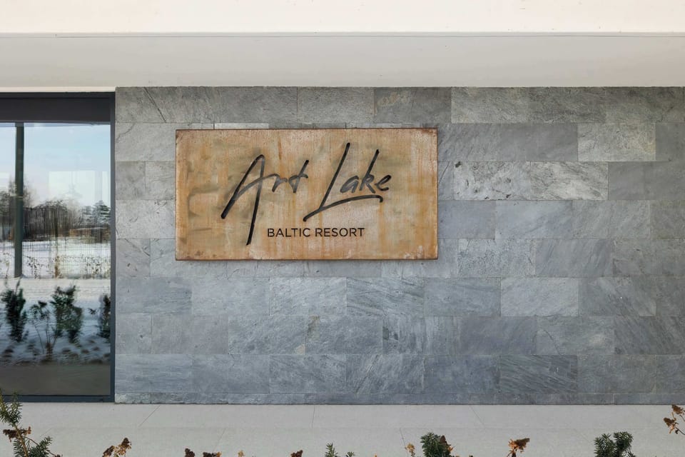 A close-up of a building sign mounted on a stone wall. The branding adds character to the exterior. The entrance feels professional and well designed.