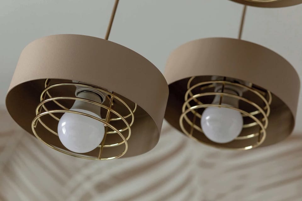 A close-up of ceiling light fixtures with gold accents. The design adds elegance to the interior. The lighting feels both decorative and functional.