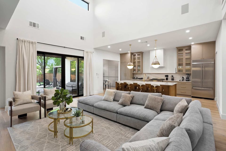Bright, airy living space with soaring ceilings, a sleek open kitchen, and seamless indoor-outdoor flow—perfect for gathering in style.