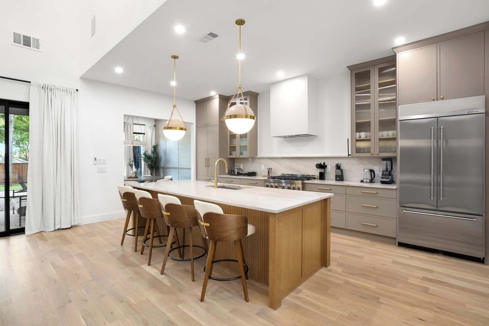 Spacious island, sleek finishes, and stylish seating: the perfect kitchen for cooking, sipping, and gathering.