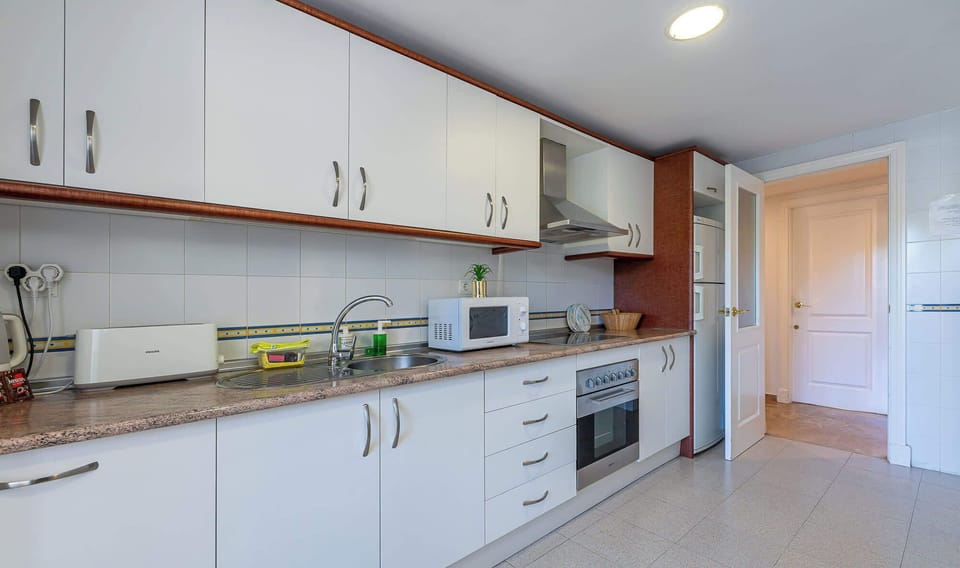 Modern kitchen with white cabinetry, granite counters, and stainless appliances. Bright, organized layout offers a clean, functional space.