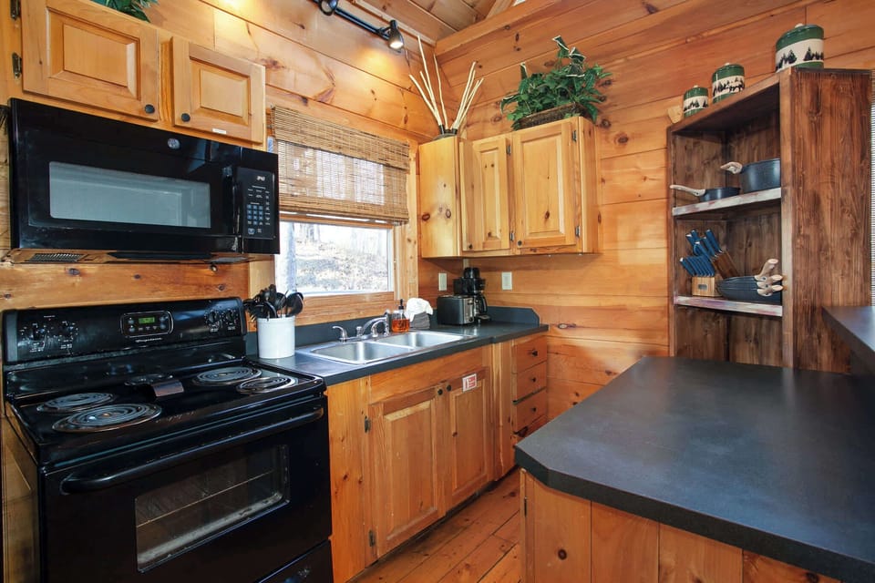 Fully equipped kitchen with black appliances and a breakfast bar for 3