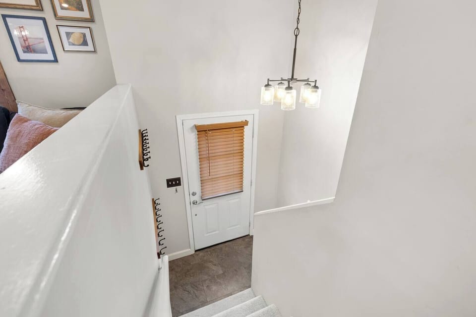 Entry with coat racks & baby gate. Steps go up to main floor or down to Bed 1