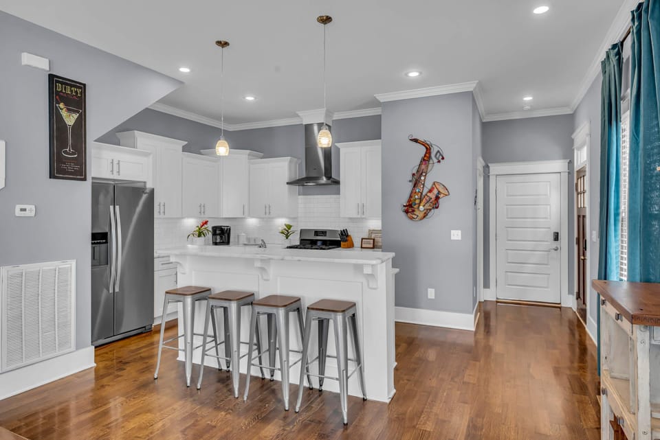 Kitchen island with bar stools turns meal prep into a social event. Pendant lights overhead keep the vibe warm while you're chopping, stirring, and catching up with your group