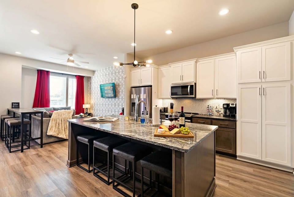 Open-plan kitchen and living room keep the cook in the conversation. Island seating lets the group gather while someone's prepping snacks for the game room night ahead