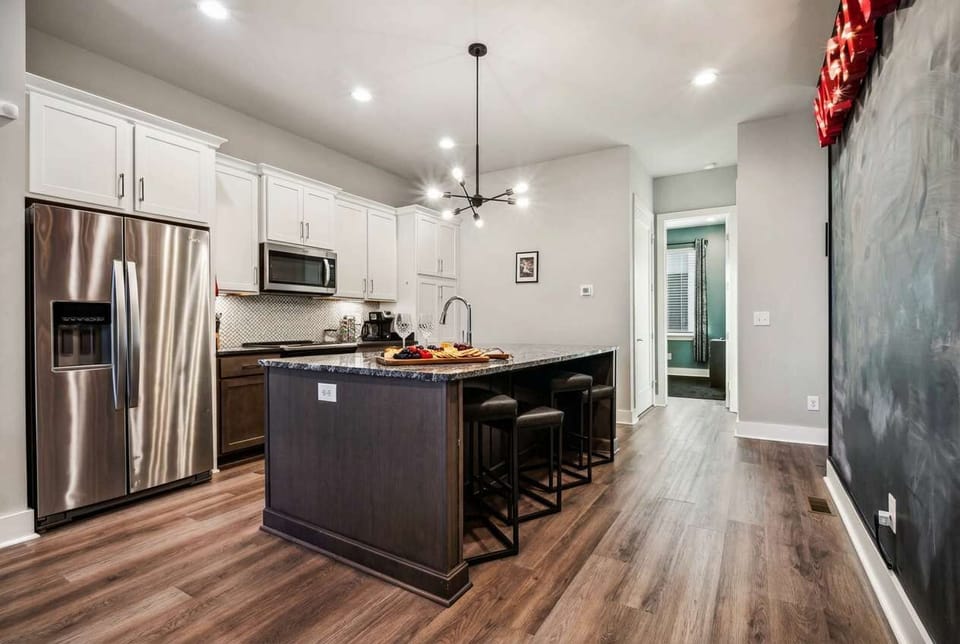 Open-plan kitchen with a large island and wood-style flooring creates the perfect setup for group meals and drink prep before the night gets started