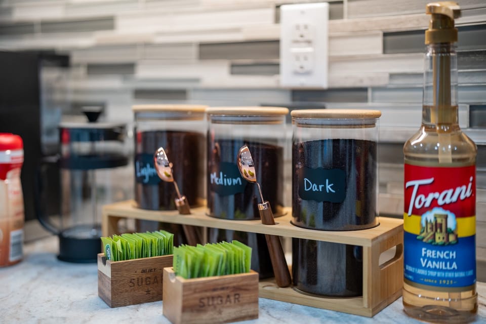 Well-stocked coffee bar with multiple roast options, sweeteners, and flavor syrups.