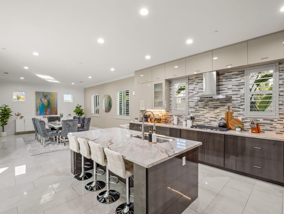 Fully equipped modern kitchen with a large island, bar seating, and open dining area for group meals.