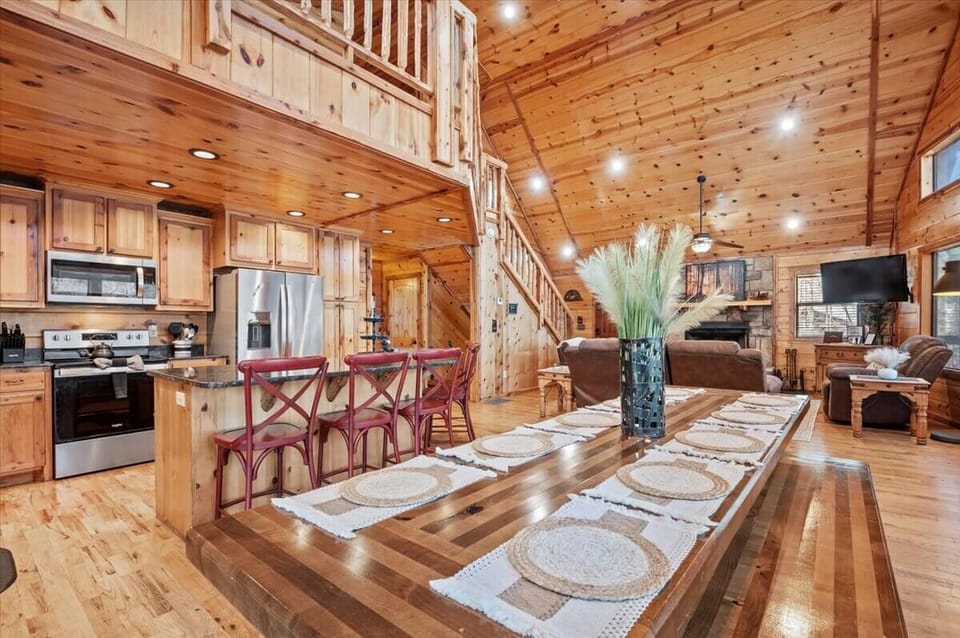Wood-filled space with kitchen island, fireplace, and warm dining area.