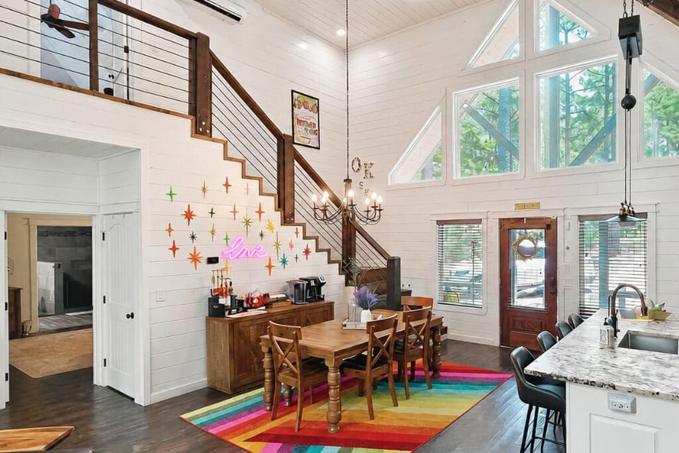 Bright open living area with soaring ceilings, staircase, and natural light.