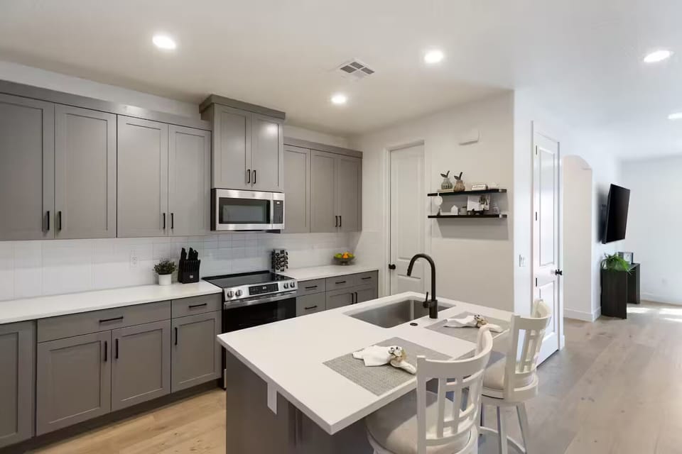 Fully stocked kitchen with brand-new stainless-steel appliances and thick solid-surface countertops opening to the great room
