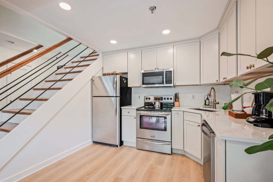 The open kitchen sits beside the staircase, so the cook stays part of the conversation.