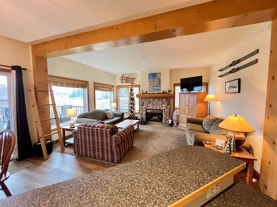A warm and cosy living area with a natural gas fireplace, smart TV with cable.