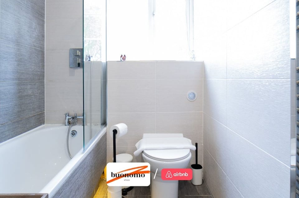 Bright and contemporary bathroom featuring a full-size bath with overhead shower and modern finishes designed for a comfortable stay.