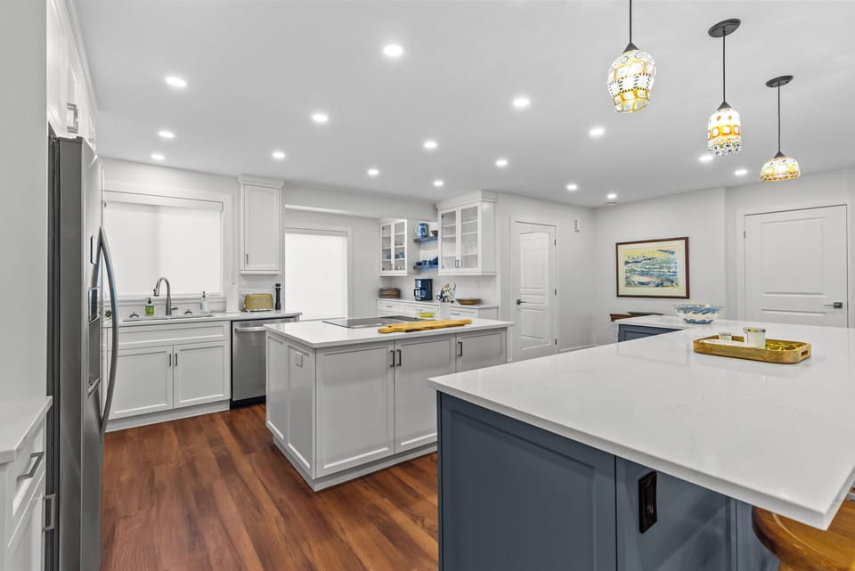 Admire the clean lines and bright design of our modern kitchen, with classic white cabinets and sleek countertops.