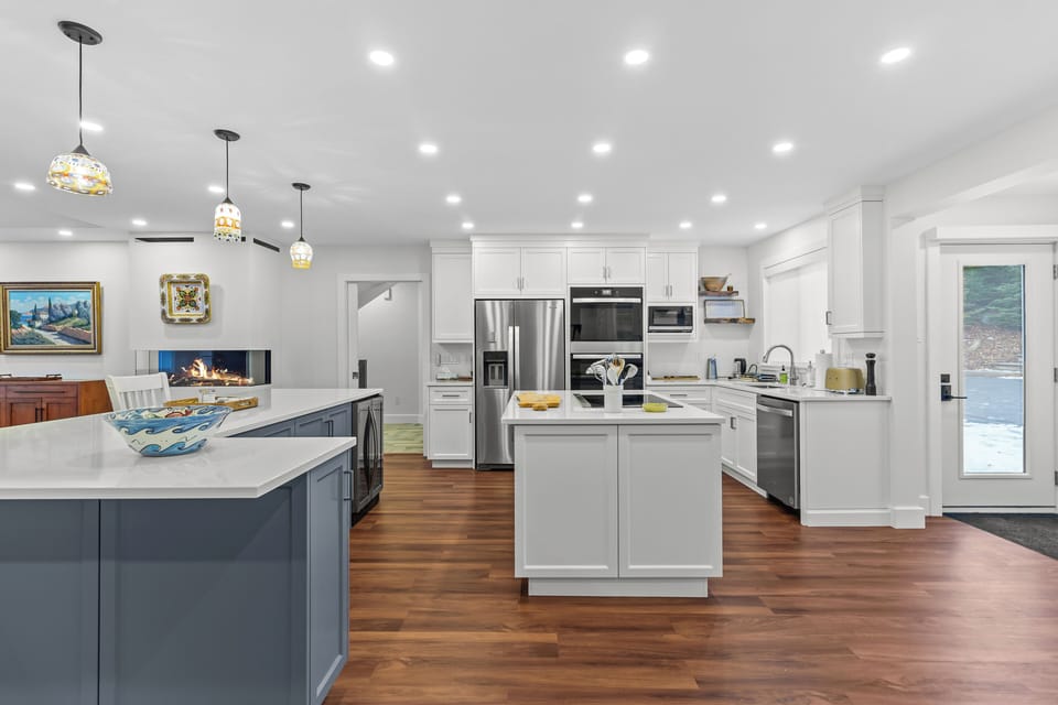 Gourmet kitchen with a massive central island, quartz countertops, and high-end stainless steel appliances, including double ovens.
