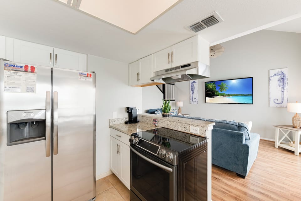 Your fully equipped kitchen features granite countertops, stainless steel appliances, and opens seamlessly to your cozy living space.