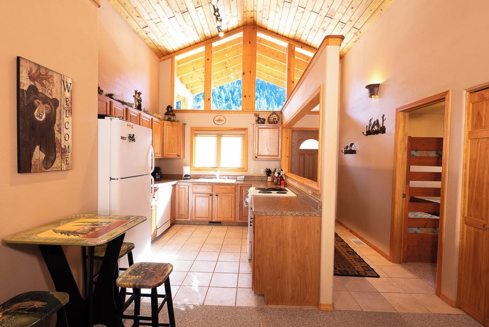 Step into your inviting mountain retreat with warm wood finishes and vaulted ceilings. Your fully-equipped kitchen makes preparing meals easy, while charming details add rustic character throughout.