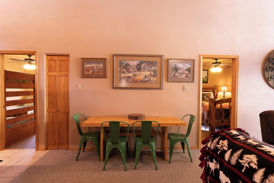 Step into your inviting dining space, where warm wood tones and rustic artwork create a welcoming atmosphere for your group to gather and share memorable meals together.