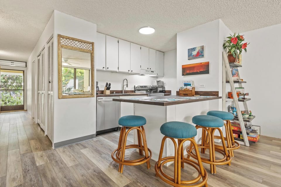 Gather with your group at the cheerful breakfast bar, where turquoise stools and warm wood tones welcome casual morning coffee or relaxed evening conversation.