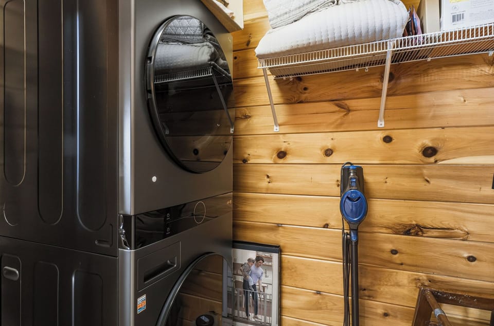 Convenient laundry setup keeps your clothes fresh during your stay. Full-size washer and dryer with organized storage above.