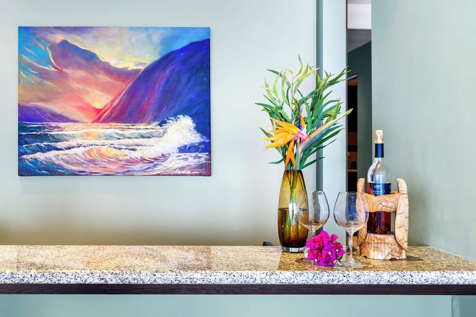 Unwind with a glass of wine in your elegant space, where vibrant artwork and tropical flowers create the perfect ambiance for relaxation.