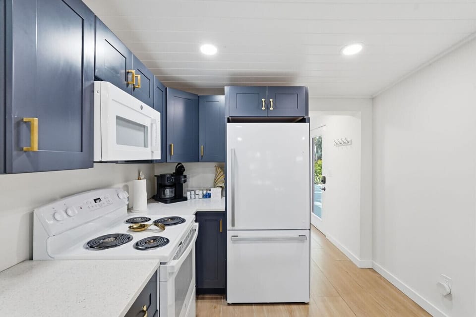 The kitchen is centrally located in the home, offering clear sightlines to the living and dining areas so you can stay connected while cooking. It features ample cabinet space, an oven, refrigerator, microwave, and sink, and is fully equipped with everyth