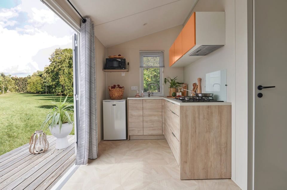 The bright and airy kitchen boasts contemporary cabinetry, modern appliances, and large windows that connect with nature.