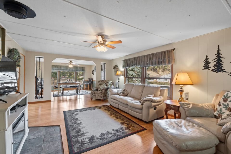 This bright and airy sitting room features a soft fabric sofa and large windows that let in plenty of natural light. The open floor plan provides a seamless flow into the adjacent lounge areas.