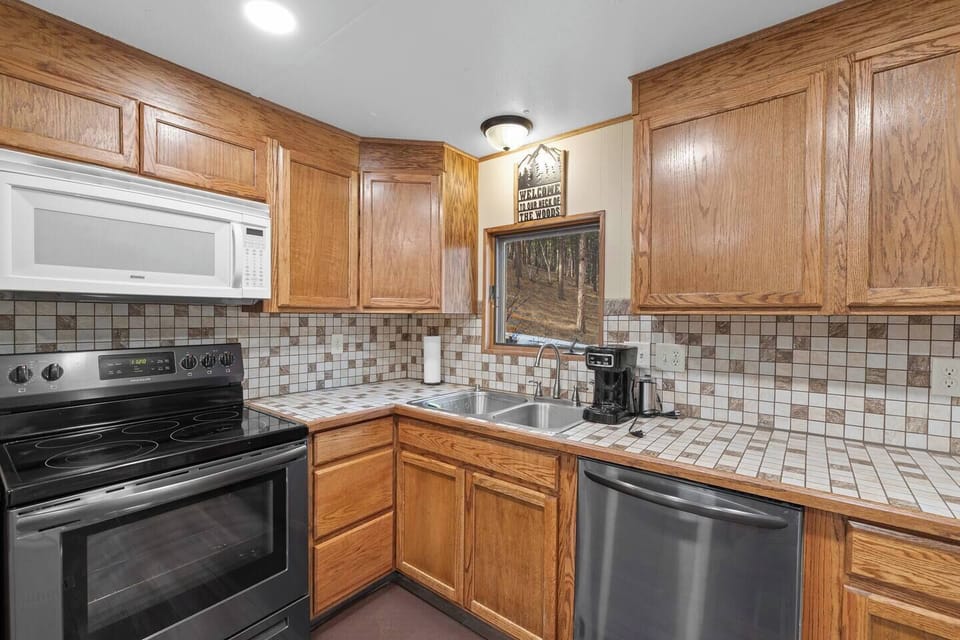 This inviting kitchen features rich wooden cabinets, a tiled backsplash, and modern appliances for easy meal prep.