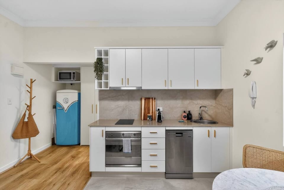 Prepare light meals in the compact kitchen, thoughtfully set up with an oven, stovetop, dishwasher, microwave, fridge, and everything needed for fuss-free cooking.