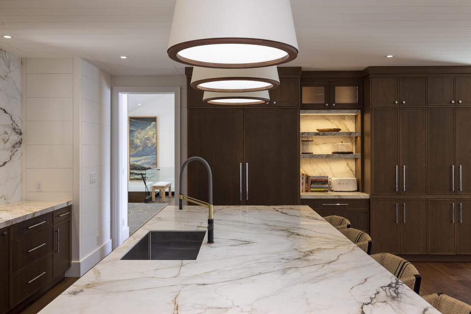 Sleek kitchen with marble island and modern lighting