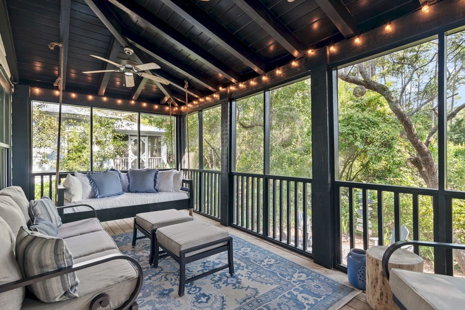 Screened Porch
A guest favorite, the screened-in porch features a cozy bed swing, sofa, rocker, and footstools. Two ceiling fans and string lights create the perfect setting for morning coffee, family time, or evening wine with peaceful wooded views.