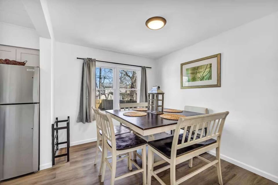Sunlit dining area w/ a classic table set near windows for easy, everyday meals.