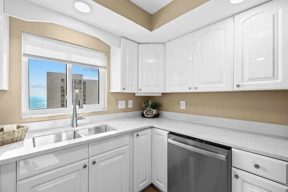 Clean white cupboards offering stylish and convenient storage space for kitchen essentials and supplies.