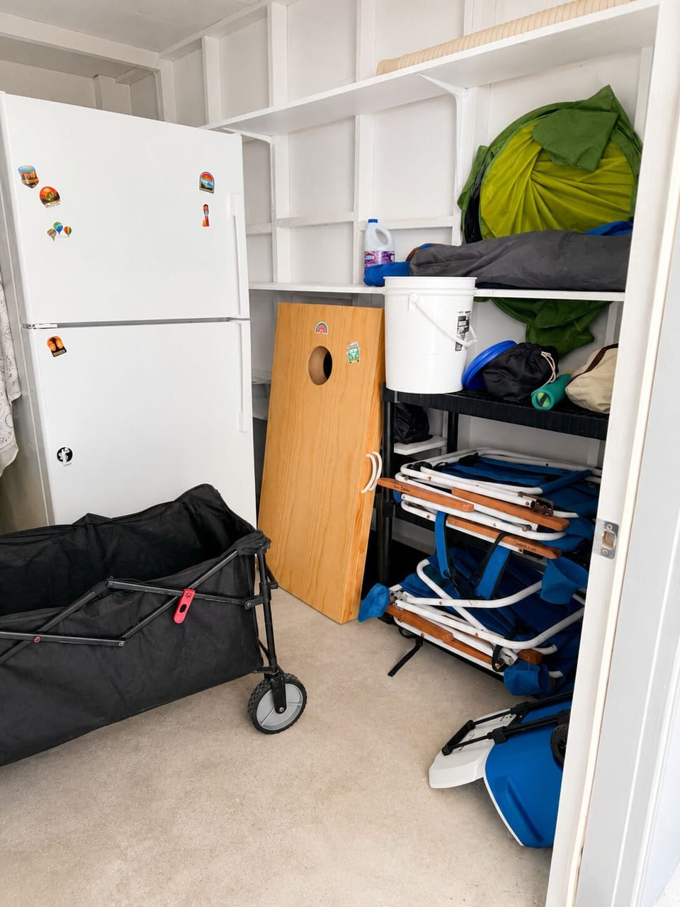Ground-level area stocked with beach gear, cornhole, and a 2nd refrigerator.