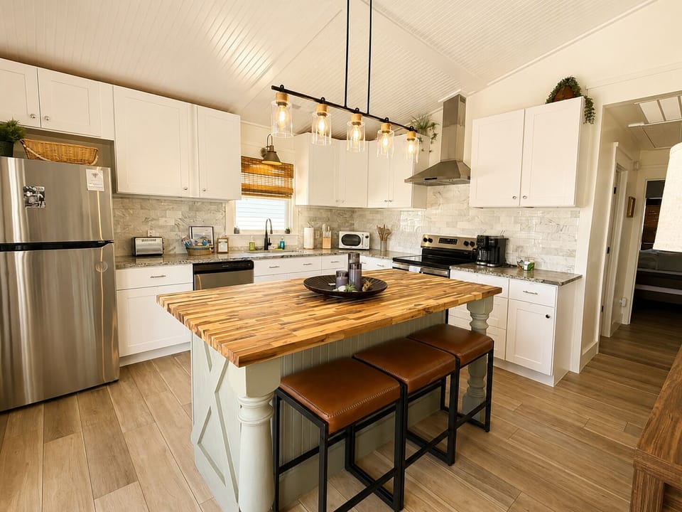 Fully equipped coastal kitchen with stainless appliances and island seating.