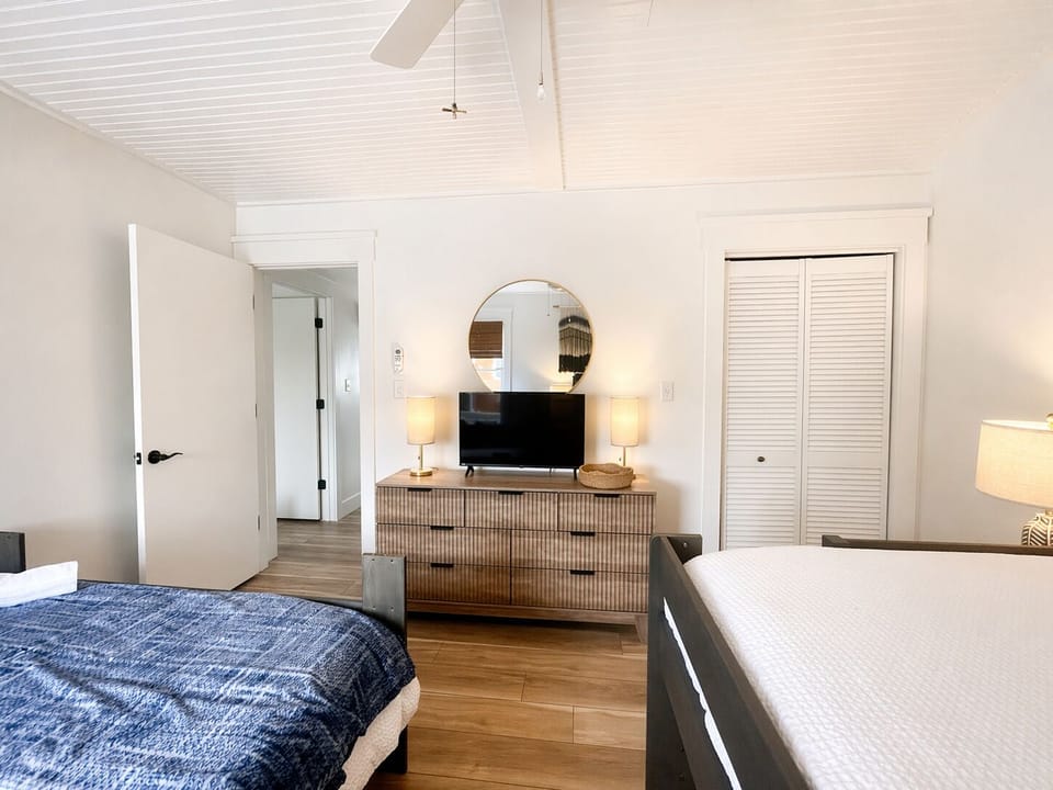Bright second bedroom offering a cozy layout, flat-screen TV, and closet space.