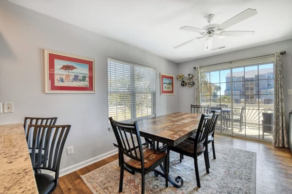 Dining table set beside balcony doors with natural light