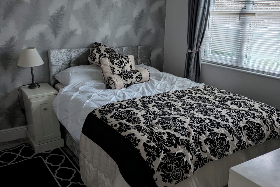 Bedroom 1 double bed and single pull out television looks out to garden 