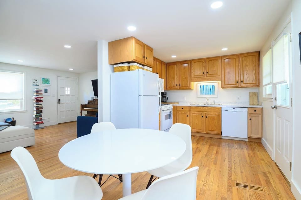 A warm, inviting dining space with seating for four, a convenient water cooler, with central access to the living room, kitchen, game room and backyard—perfect for meals, coffee, or planning your day.
