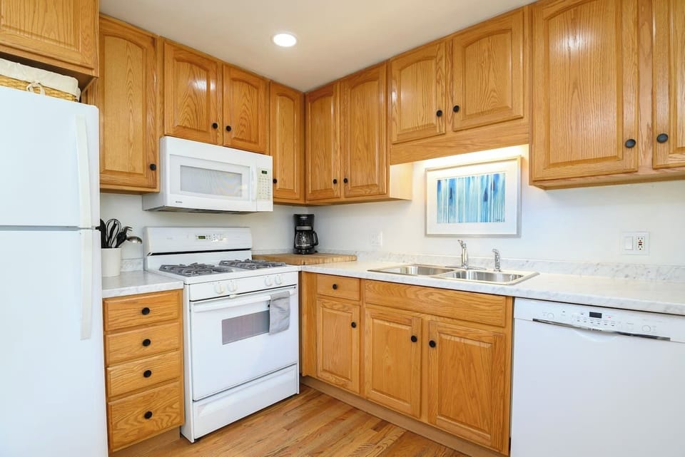 Cook with ease in a bright kitchen featuring ample cabinet space, microwave, dishwasher, fridge, oven, drip coffee maker, double‑basin sink, and all the essentials. Direct access to the backyard makes outdoor dining a breeze.