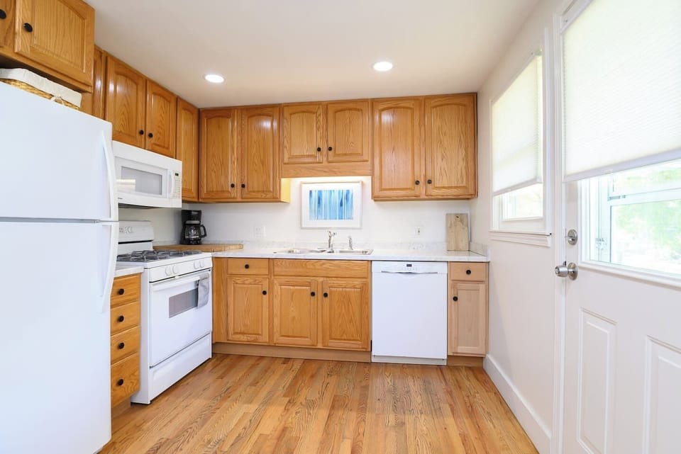 Cook with ease in a bright kitchen featuring ample cabinet space, microwave, dishwasher, fridge, oven, drip coffee maker, double‑basin sink, and all the essentials. Direct access to the backyard makes outdoor dining a breeze.