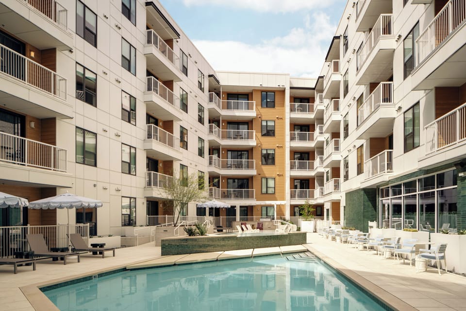Elevated view of the resort offers a communal pool, outdoor kitchen, and multiple lounge areas.