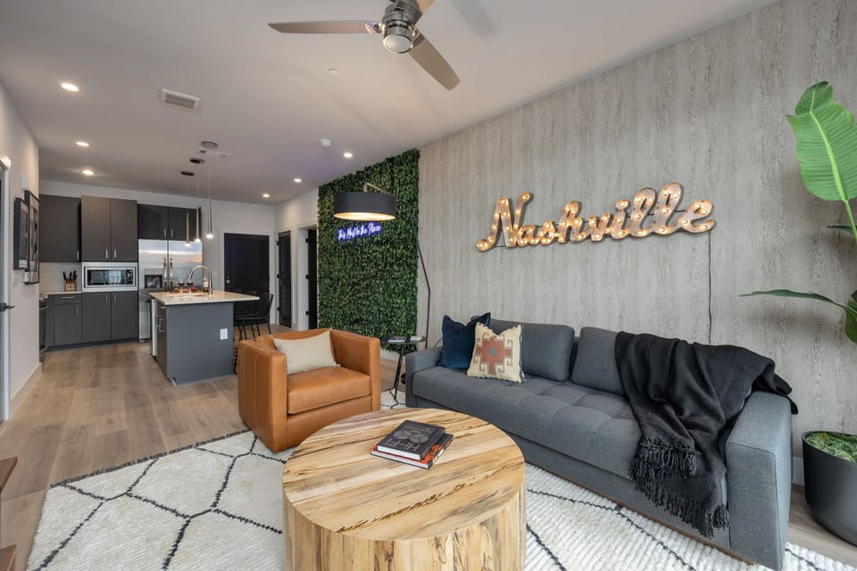 Chic living room detail showcasing the leather accent chair and the large "Nashville" wall art.