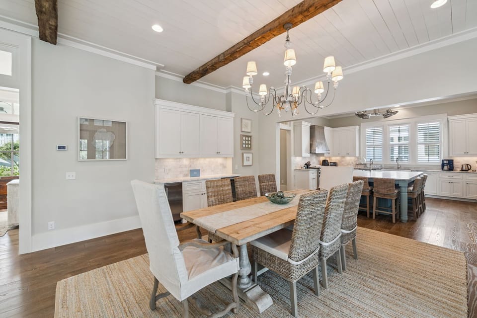 Your open-plan dining and kitchen space features rustic beams, elegant chandelier, and farmhouse table where you'll create lasting memories over shared meals.